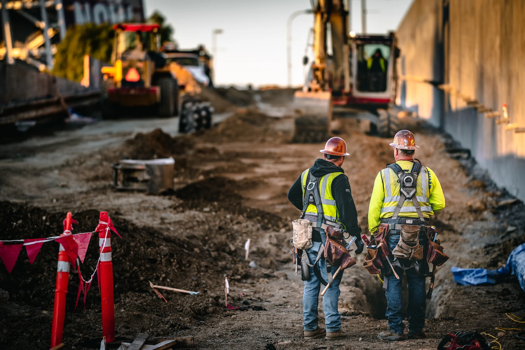Two workers in safety equipment at a construction site